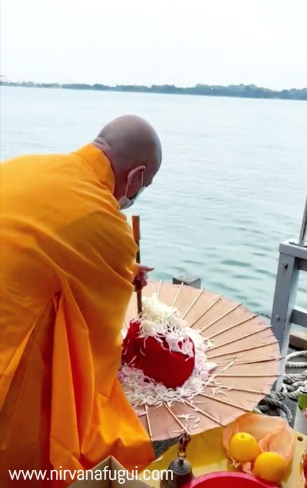 The priest performs chanting ritual before family members scatter the ashes into the open seas