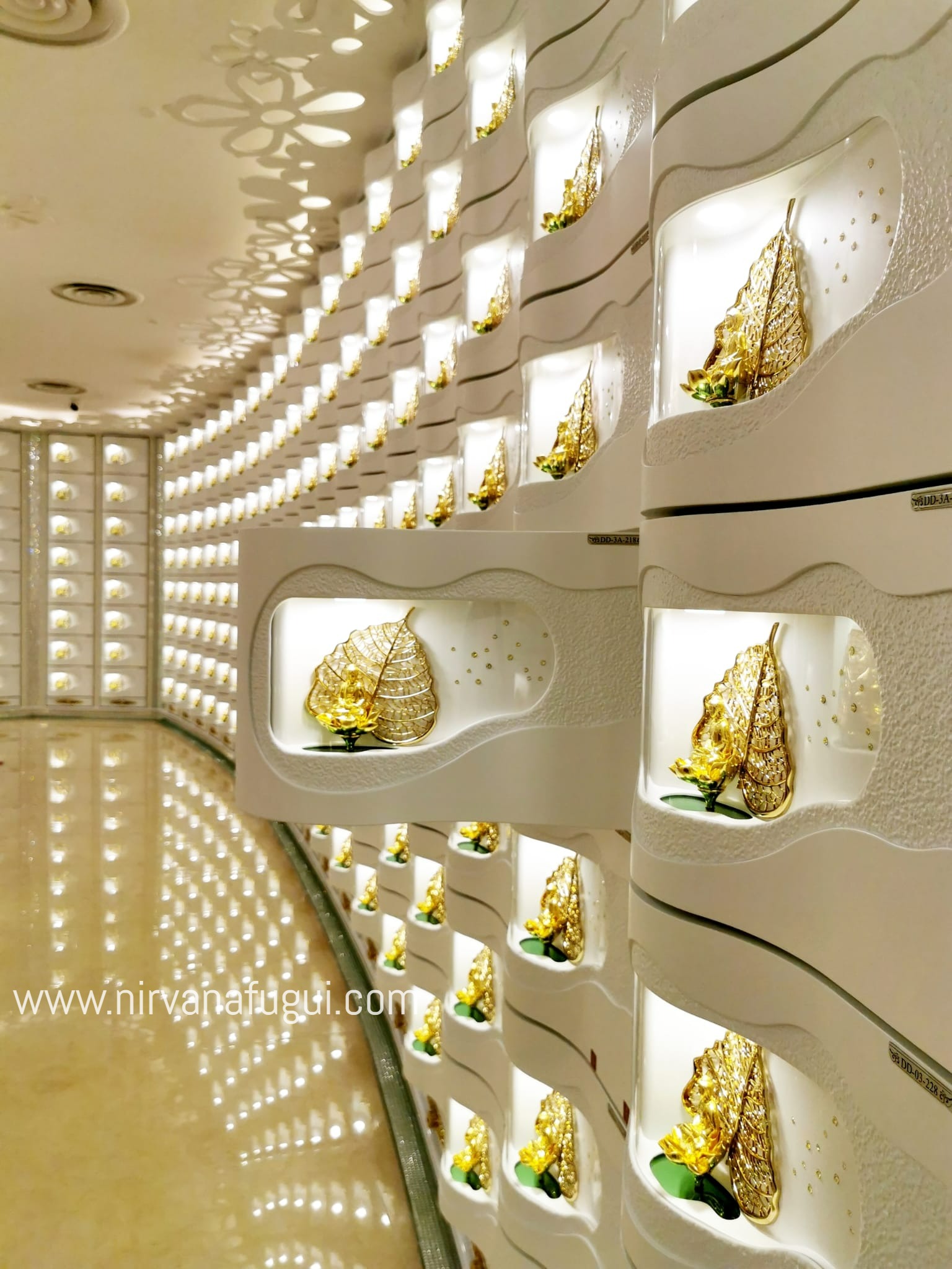 The niche of this columbarium has built-in golden Buddha at the panel.